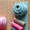 Εύχρηστος φορητός εξοπλισμός γυμναστικής, όπως ελαστικές ζώνες, ελαφρά βαράκια και στρώμα γιόγκα, τοποθετημένα σε ένα φωτεινό, ανοιχτόχρωμο δωμάτιο, προωθώντας την άσκηση στο σπίτι.