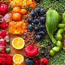 Μια διάταξη από φρέσκα, οργανικά φρούτα, λαχανικά και σπόρους σε ξύλινη επιφάνεια, σε γήινους τόνους, που εκπροσωπεί την υγιεινή διατροφή και τις θρεπτικές επιλογές.