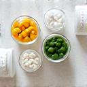 Χρωματιστά συμπληρώματα διατροφής σε διαφανή δοχεία, τοποθετημένα σε καθαρό, μινιμαλιστικό φόντο, που αναδεικνύουν την ποιότητα και την ποικιλία.